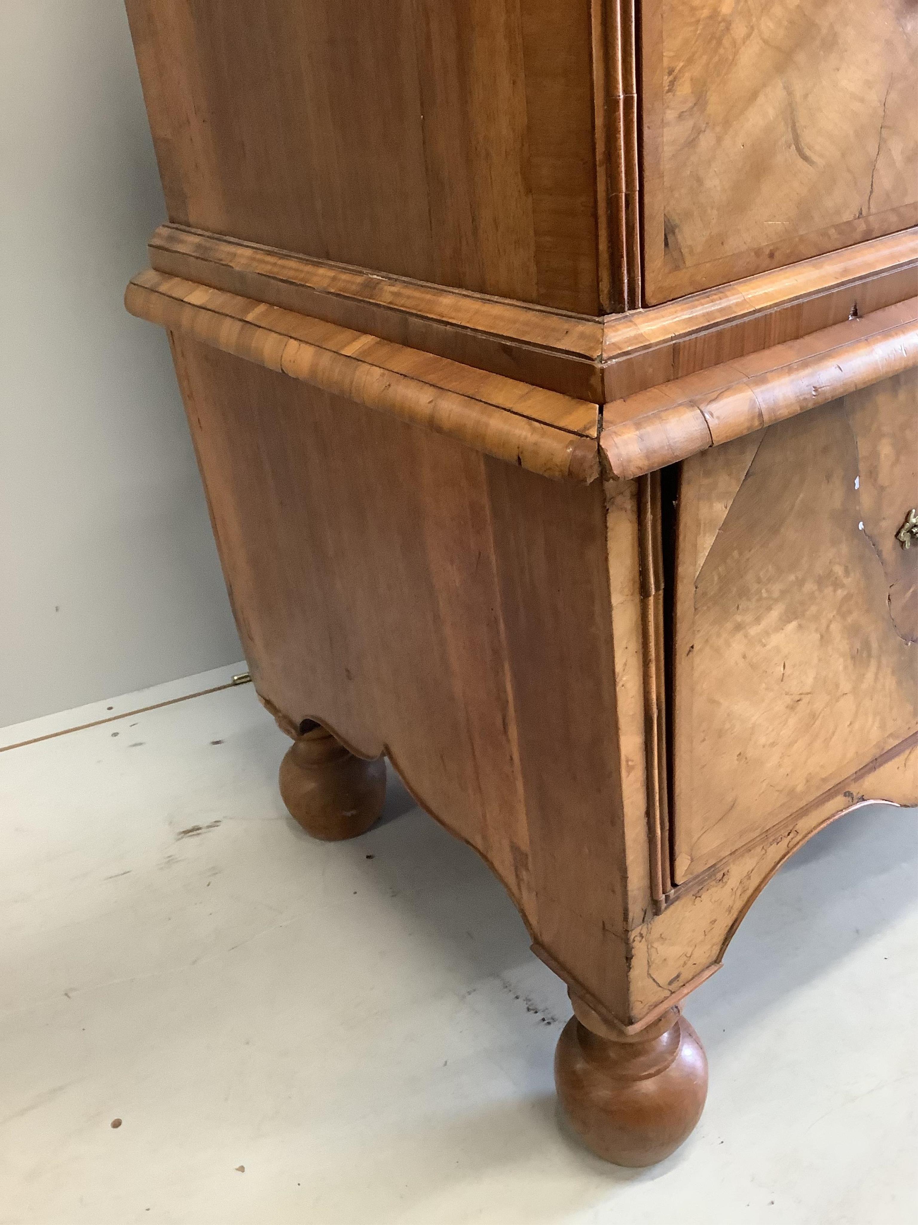 An early 18th century walnut chest on stand with later bun feet, width 106cm, height 147cm. Condition - fair